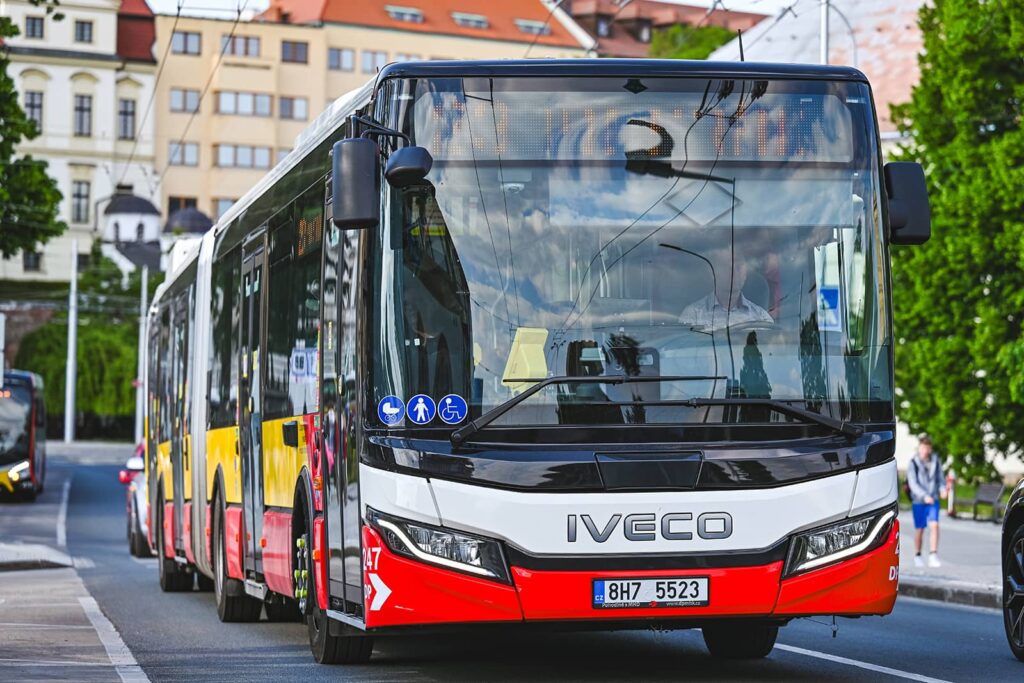Pohled ze předu na kloubový autobus jedoucí ze zastávky Zimní stadion