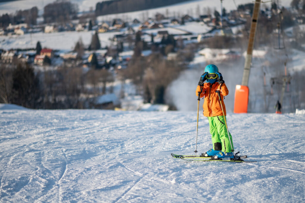 Malý lyžař na sjezdovce ve Ski areálu Deštné v Orlických horách