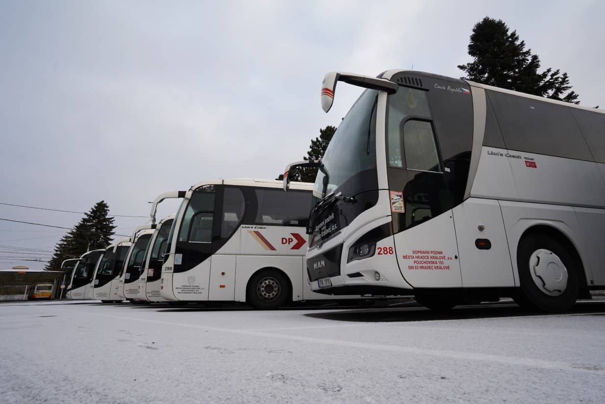 V zimě vedle sebe zaparkované autobusy zájezdové dopravy v areálu dopravního podniku