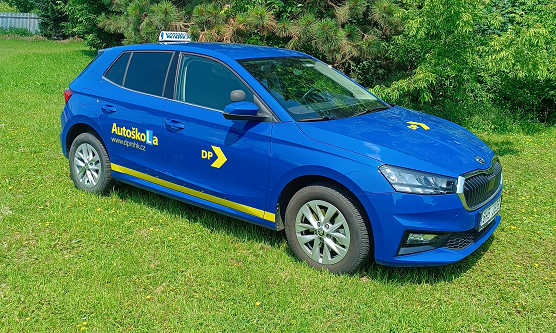 Vozidlo autoškoly - modrá Fabia na trávníku u autoškoly