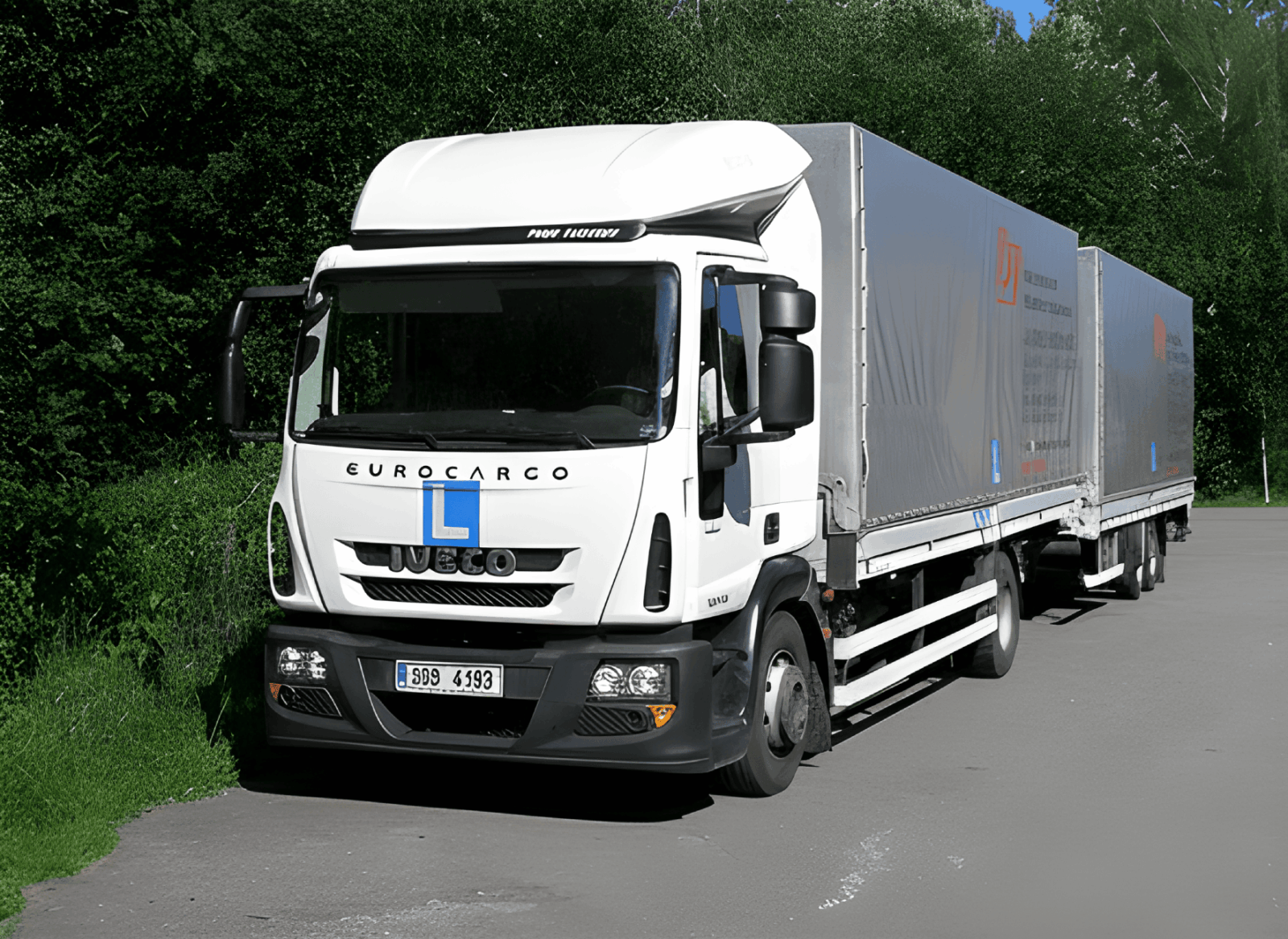 Vozidlo autoškoly - nákladní vůz Iveco s přívěsem na parkovišti