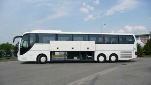 Autobus zájezdové dopravy na parkovišti s otevřeným zavazadlovým prostorem