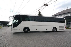 Autobus zájezdové dopravy z boku odjíždí od dispečinku