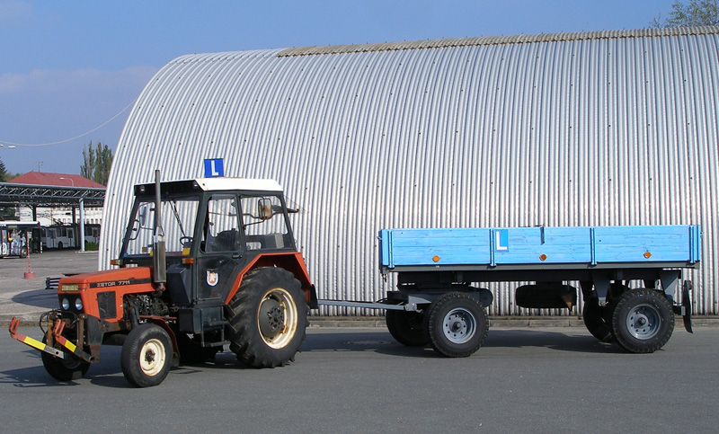 Vozidlo autoškoly - traktor s přívěsem na parkovišti