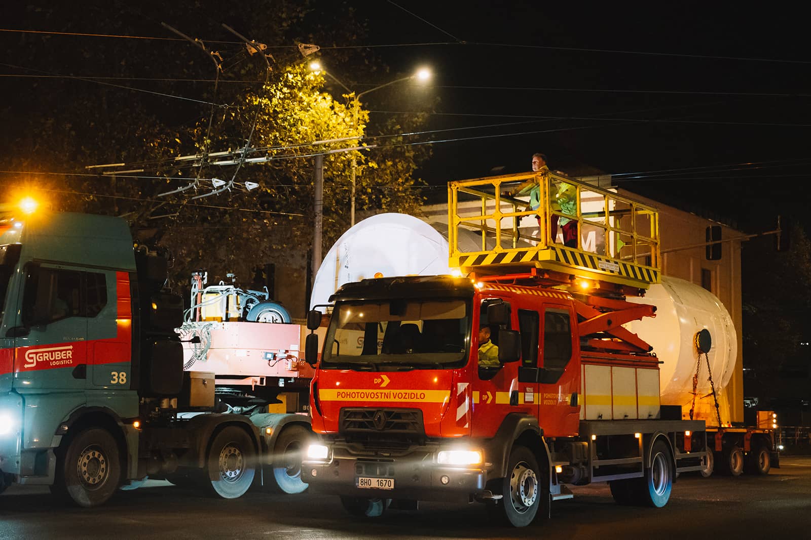 Pohotovostní vozidlo dopravního podniku a zásah střediska trakčního vedení při večerním průjezdu nadměrného nákladu