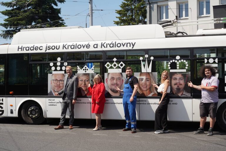 Zaměstnanci stojí u své fotografie na trolejbusu před dispečinkem v rámci oslav 800 let města v roce 2025