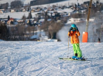 Malý lyžař na sjezdovce ve Ski areálu Deštné v Orlických horách